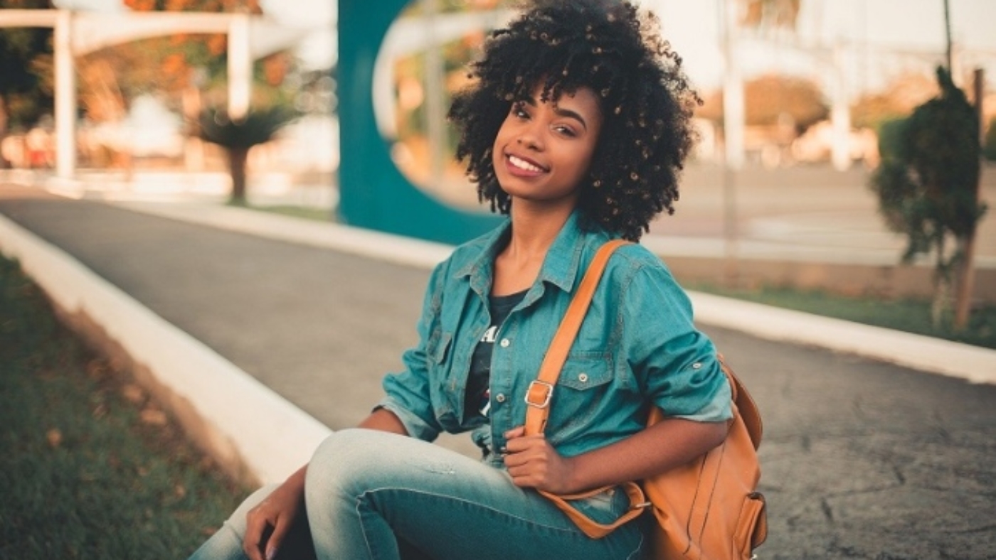 benefits of studying abroad [image of a female student sitting on a pavement]